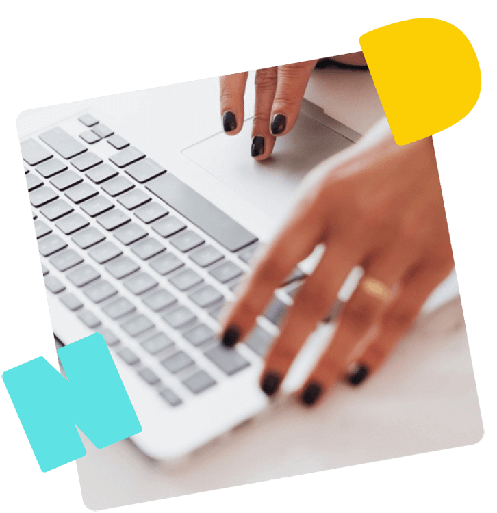 Eine Frau mit lackierten Fingernägeln arbeitet an einem Laptop.