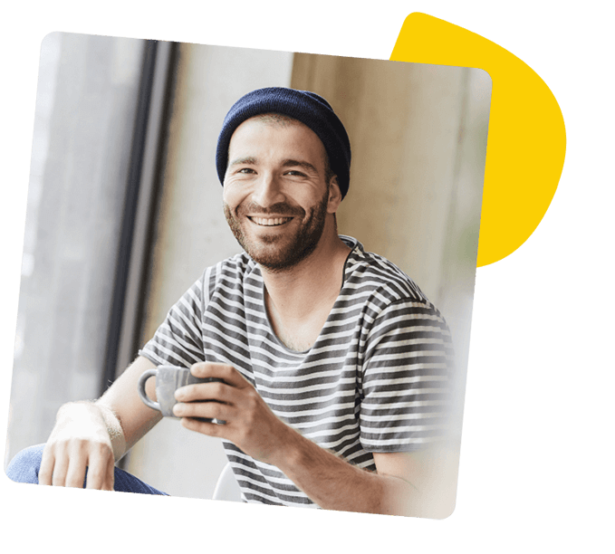 Bild eines lächelnden Mannes mit Kaffeetasse in der Hand.