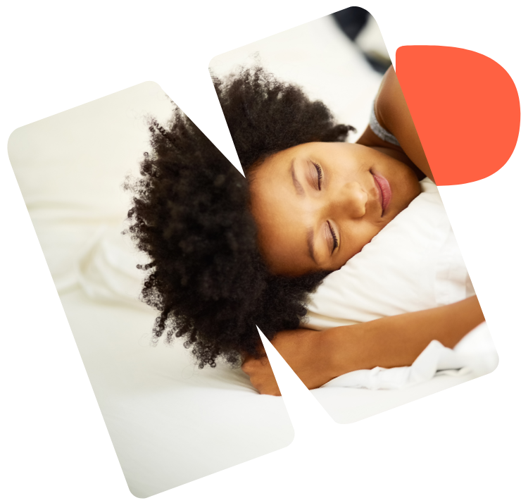 Eine Frau schläft in einem Bett mit weißer Bettwäsche. 