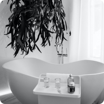 Ein schwarzweiß Bild von einer freistehenden Badewanne.