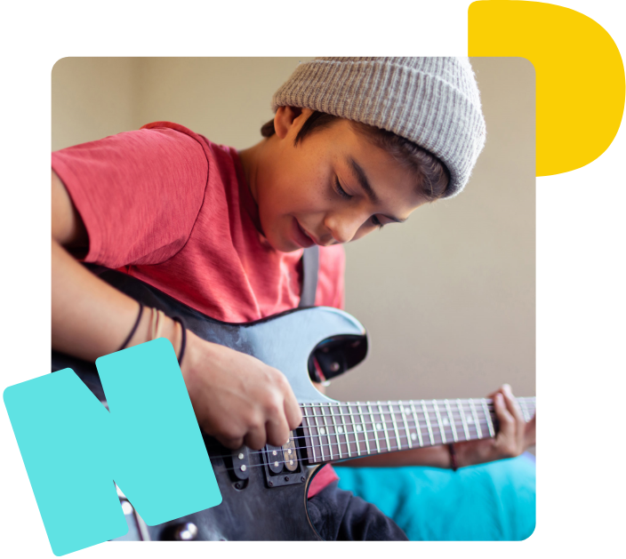 Ein junge spielt auf einer schwarzen E-Gitarre. 