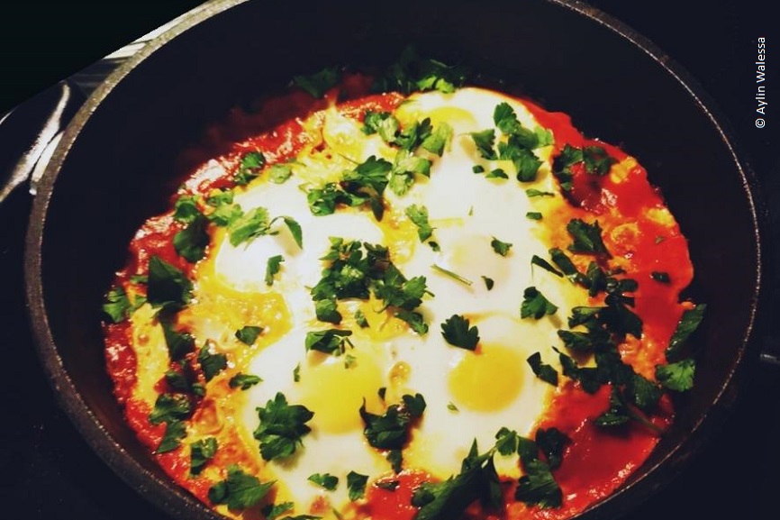 Ein Topf aus Gusseisen gefüllt mit Shakshuka. 