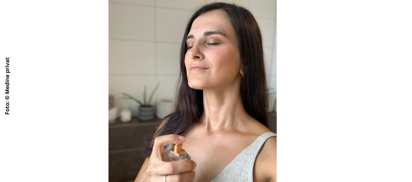 Medine besprüht ihren Hals mit einem Parfum.