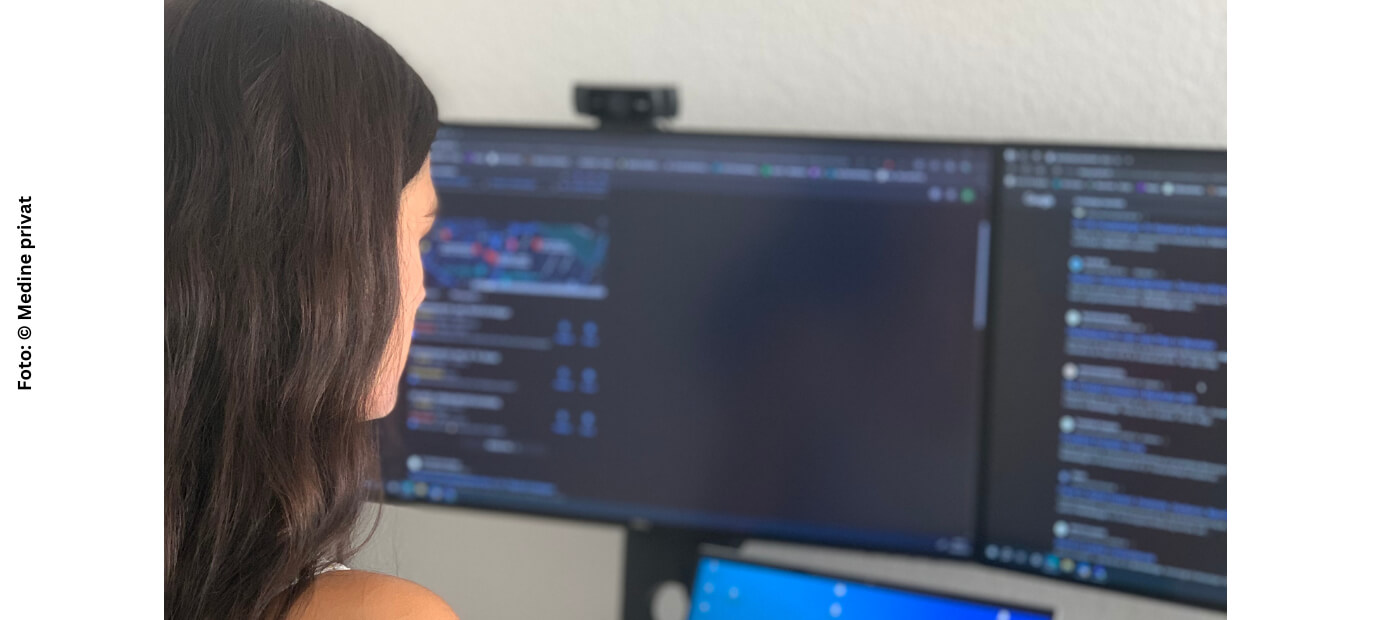 Medine schaut auf einen Computerbildschirm.