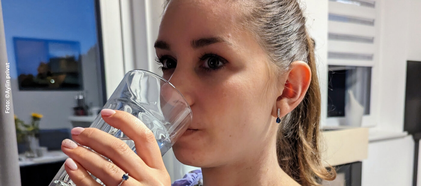 Eine Frau trinkt Wasser aus einem Glas.
