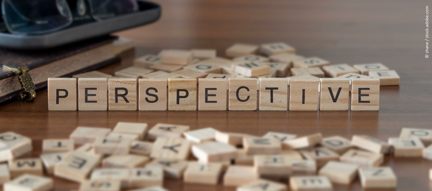 Auf einem Holztisch wurde mit Scrabble Steinen das Wort "Perspective" gelegt. 