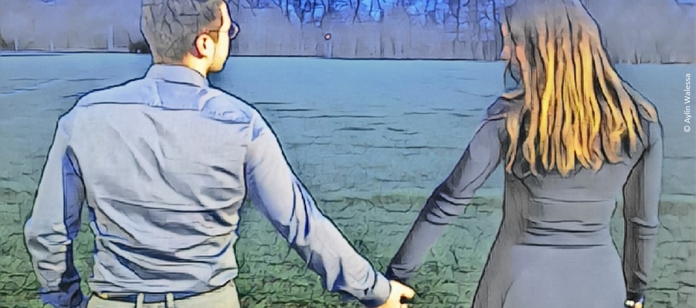 Aylin hält die Hand eines Mannes. Beide sind von hinten zu sehen. 