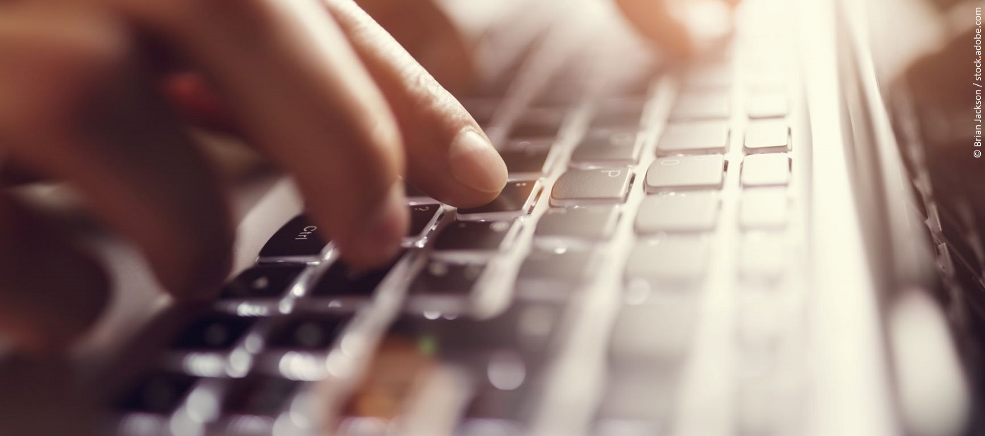 Finger tippen auf einer Tastatur. 