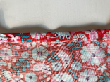 Roter Stoff mit bunten Blumen. 