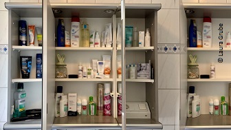 Ein geöffneter Badezimmerspiegelschrank mit diversen Cremes und Hygieneartikeln. 