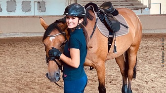 Medine im Reiterhelm mit einem Pferd. 