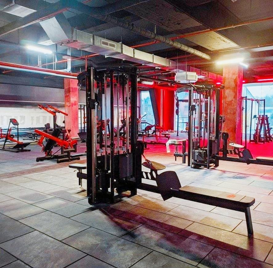 Bild einer Fitnessfläche mit verschiedenen Trainingsgeräten. 