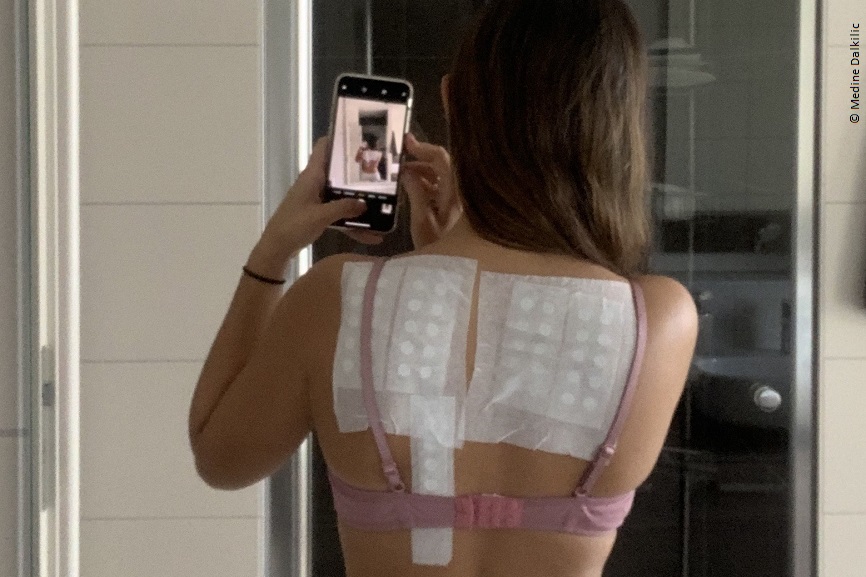 Medine macht ein Foto von ihrem Rücken. 