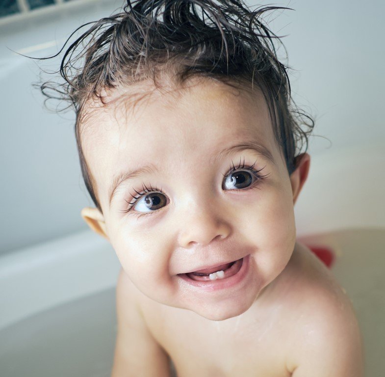 Ein Baby im Bad mit einer gelben Quietscheente