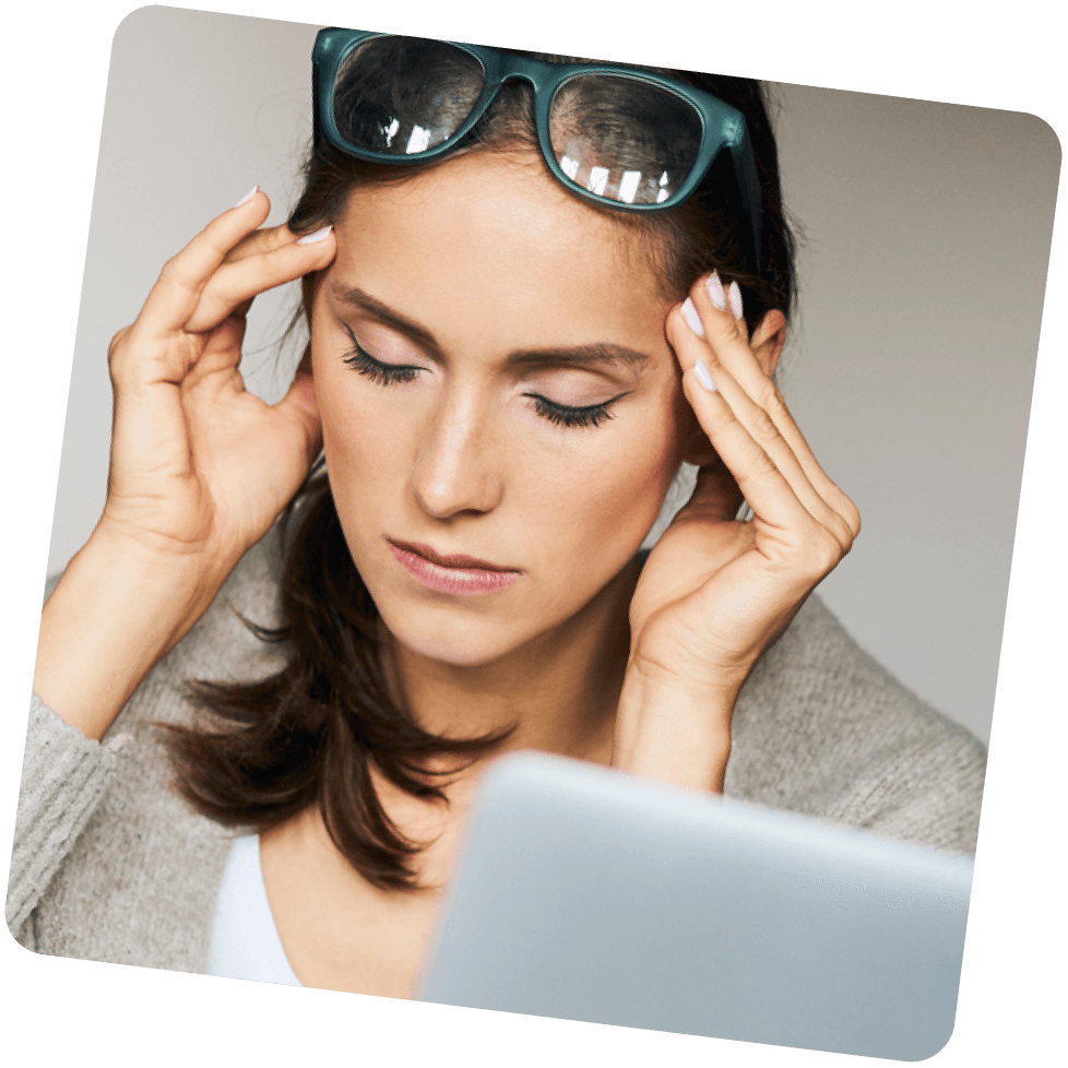 Neurodermitis-Patientin sitzt unkonzentriert am Arbeitsplatz