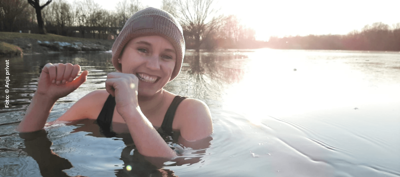 Junge Frau mit Neurodermitis im See beim Eisbaden