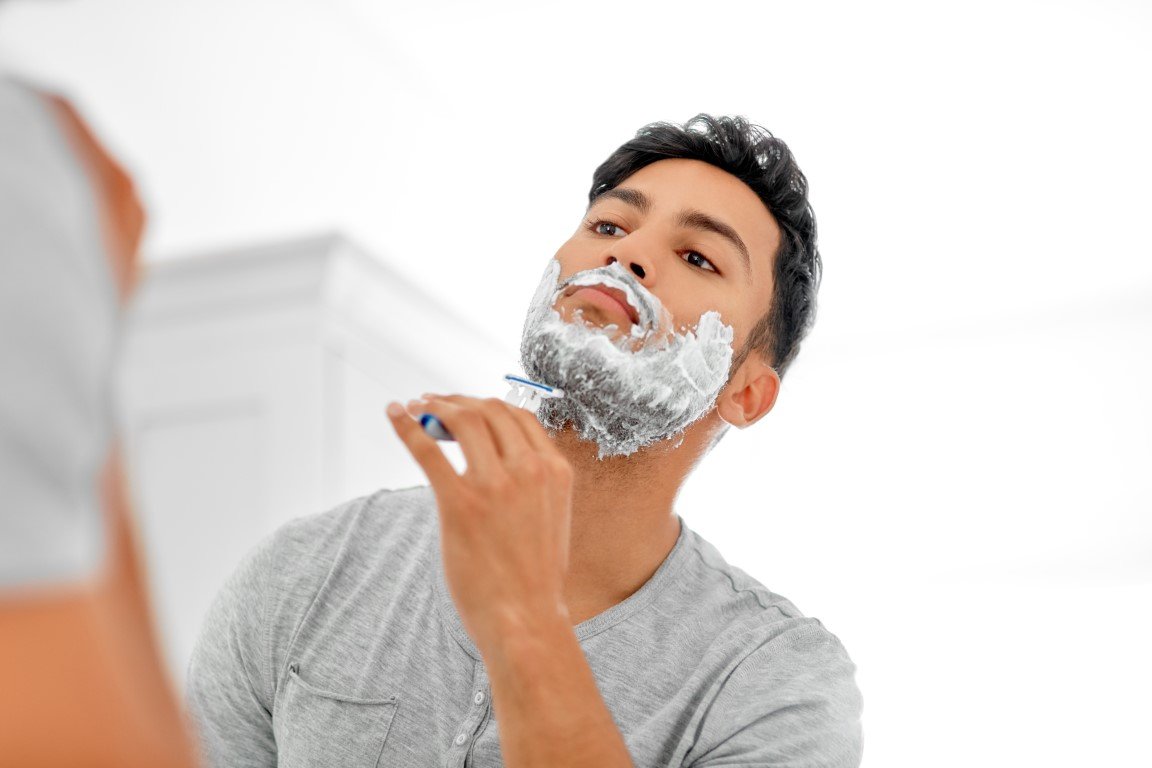 Mann rasiert sich im Gesicht