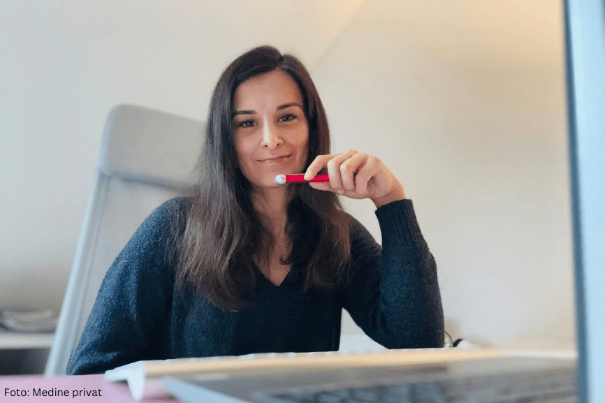 Frau sitzt am Schreibtisch und arbeitet