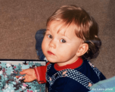 Laura als Kleinkind mit leichten Rötungen an den Wangen beim Puzzeln