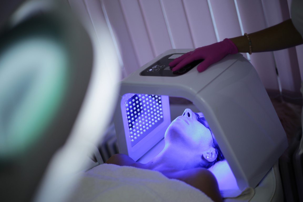 Frau erhält eine Therapiemit UV-Licht im Gesicht