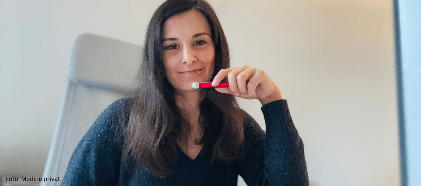 Frau sitzt am Schreibtisch und arbeitet