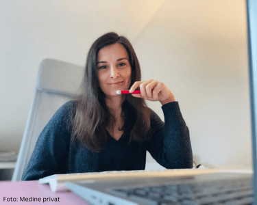 Frau sitzt am Schreibtisch und arbeitet