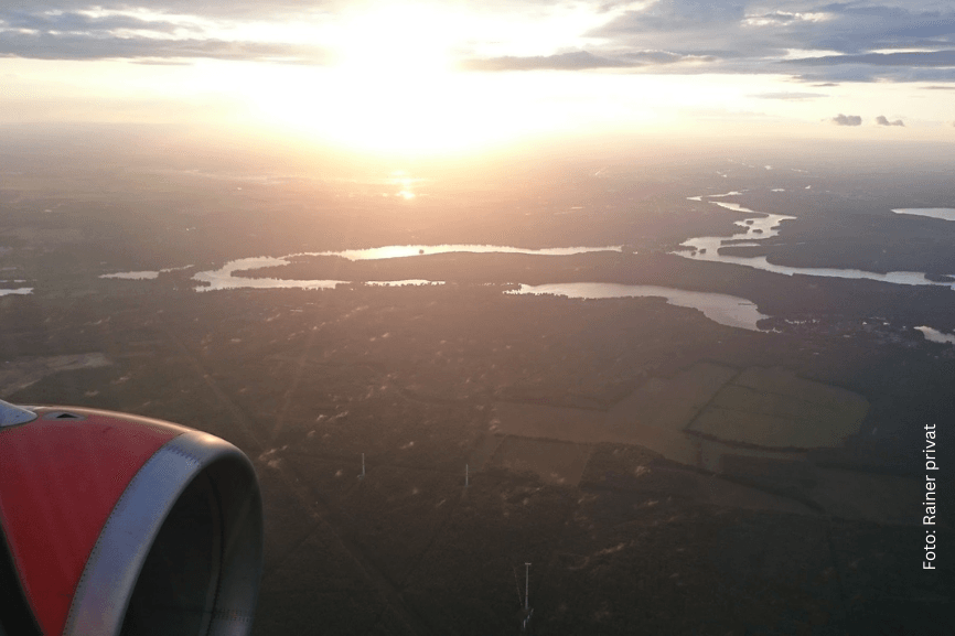 Blick aus dem Flugzeugfenster bei Sonnenuntergang