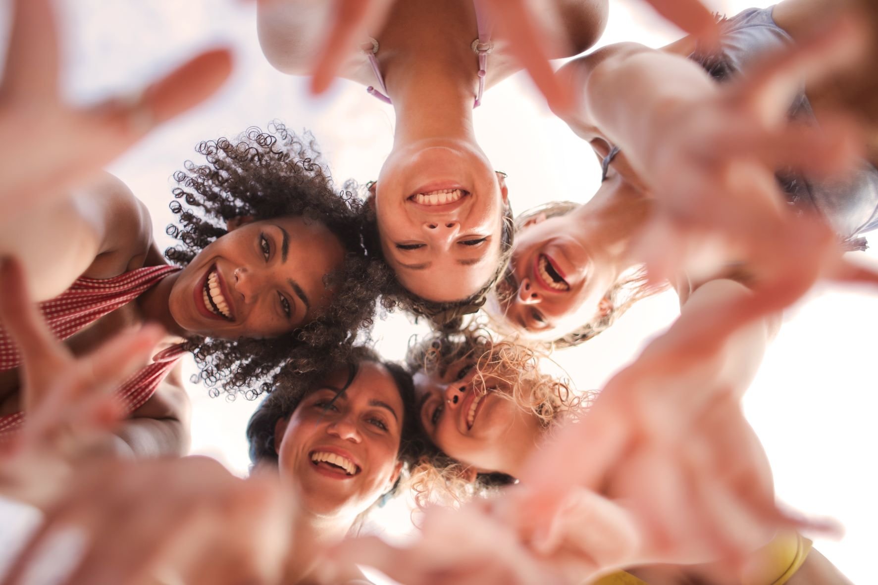 Eine Gruppe junger Frauen, die fröhlich in die Kamera lachen.