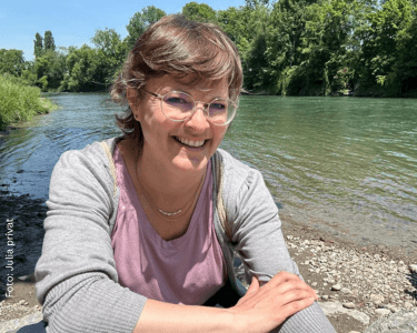 Julia an einem See – sie genießt den Stressabbau durch Sport bei Neurodermitis